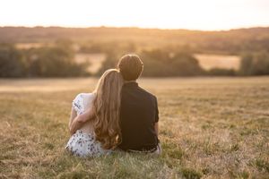 Romantic sunset silhouettes in a golden field during engagement photography session.