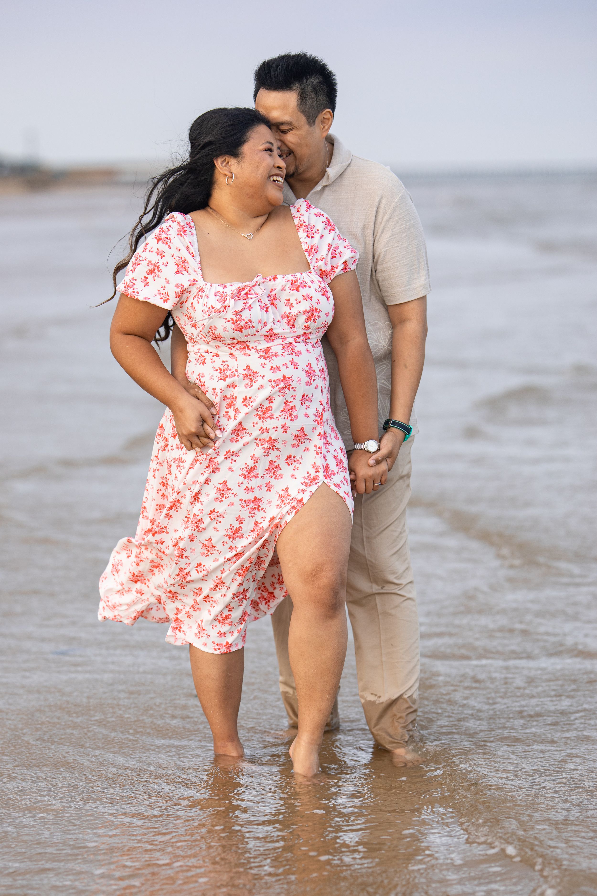 A couple sharing an intimate moment while standing in the ocean waves.
