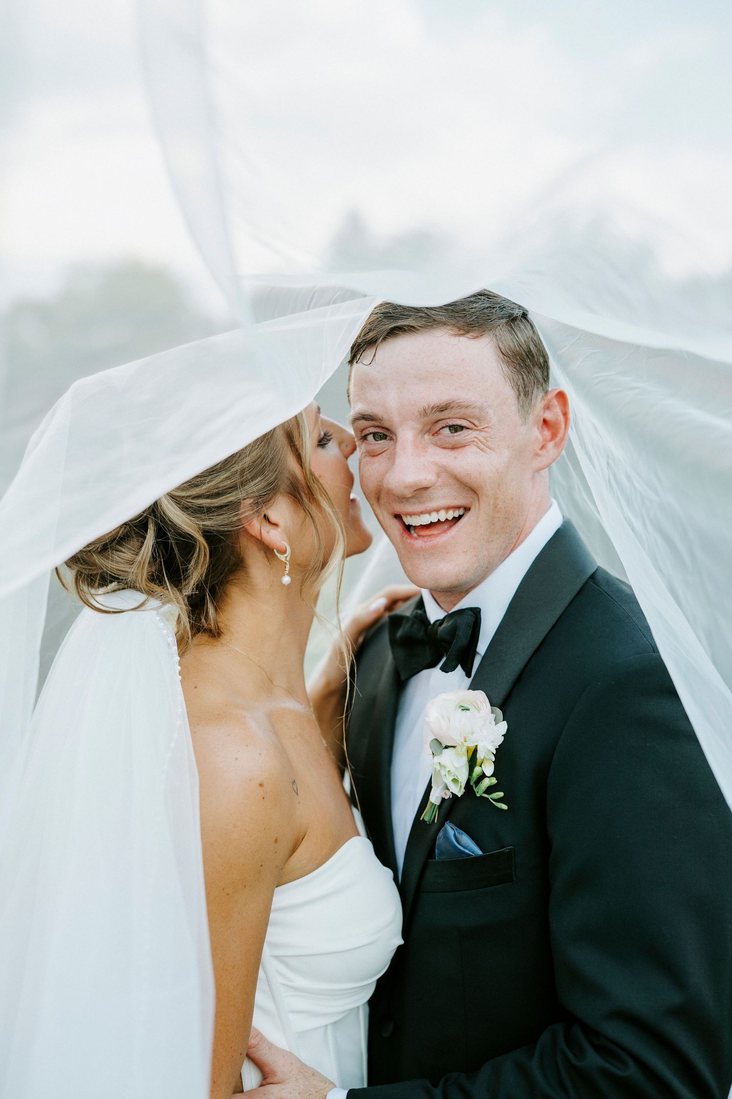 Romantic wedding photography sequence under a flowing white veil in natural light.