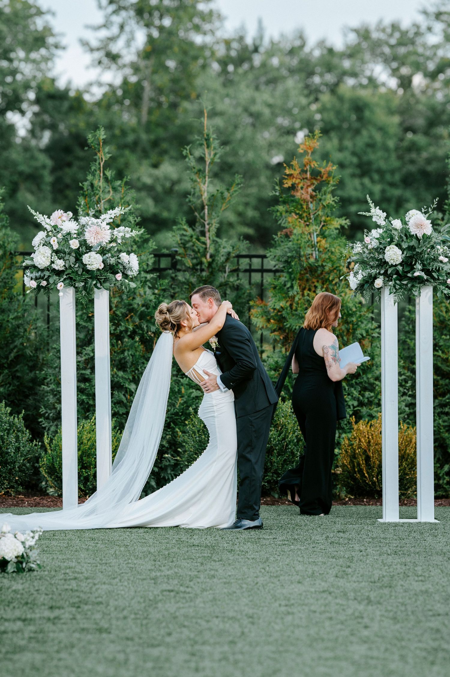 A wedding ceremony in an outdoor garden setting with white columns and flowing fabric decor spanning a series of images.
