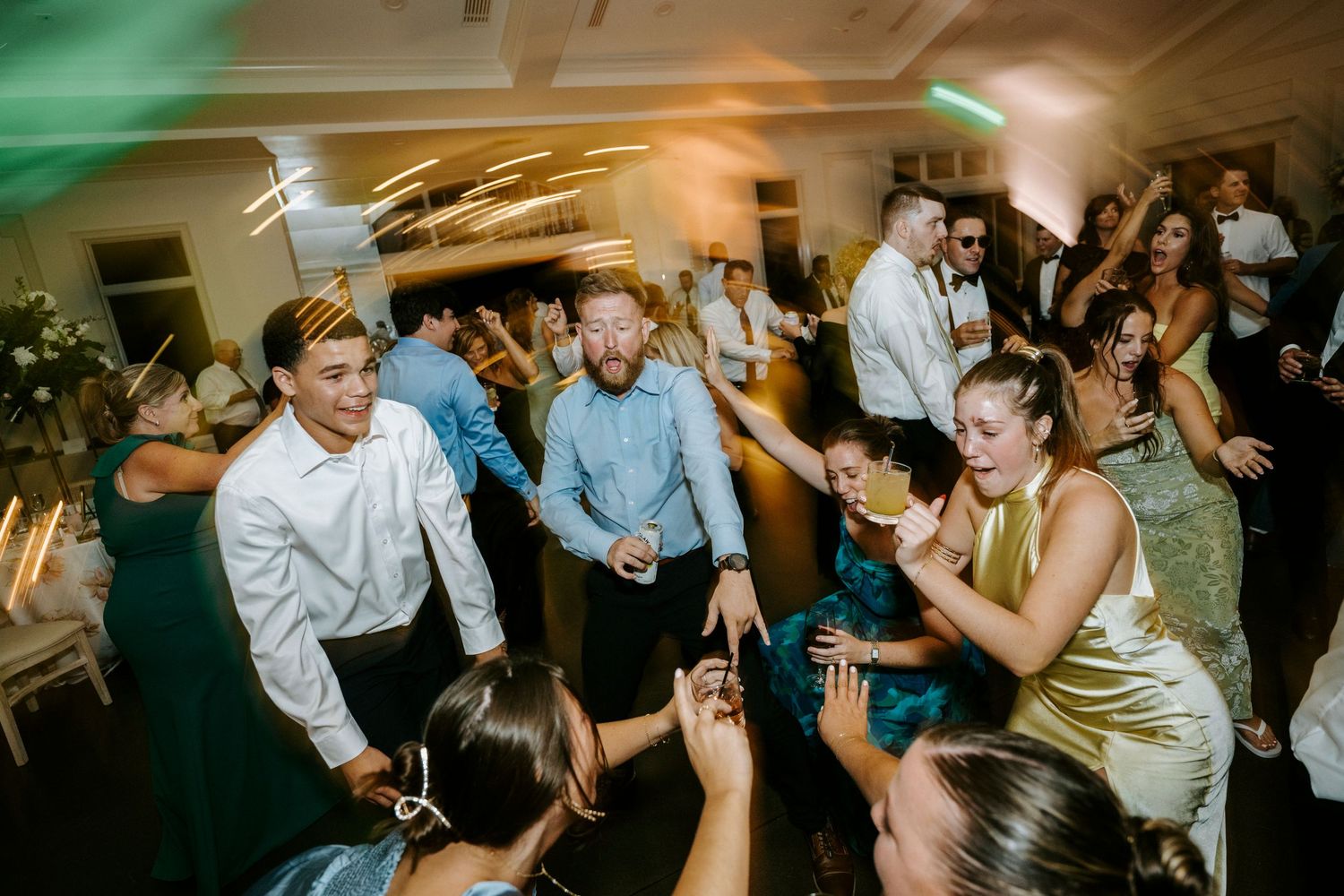 Wedding reception dance floor filled with guests dancing and celebrating.