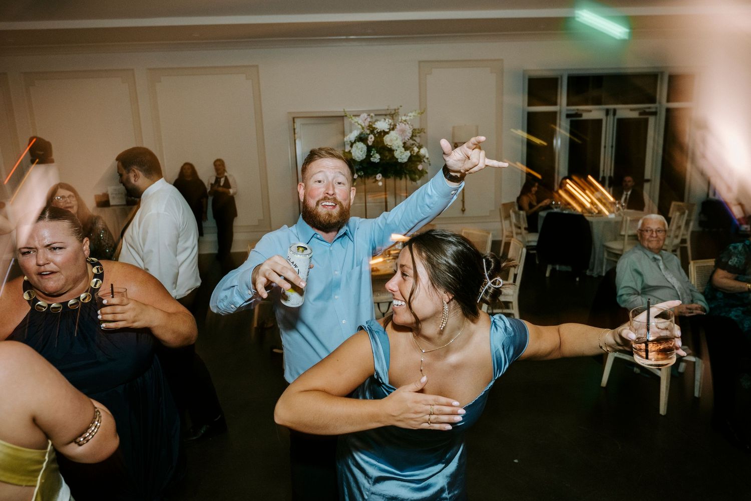 Energetic dance floor moments captured during a lively wedding reception celebration.
