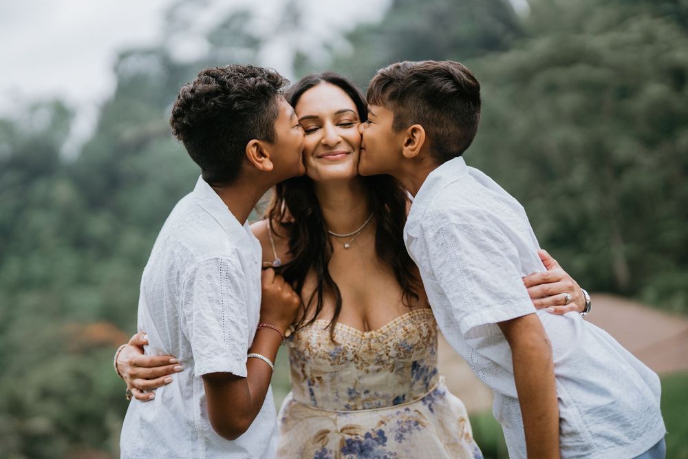 Sweet family embraces captured during outdoor photo session in tropical setting.