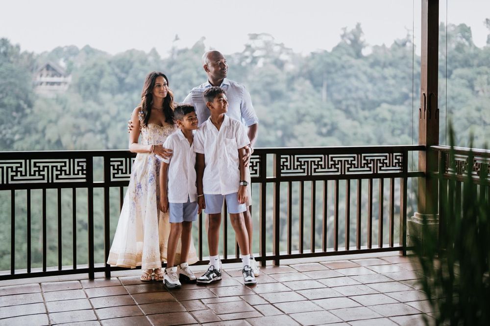People enjoy a relaxing moment on a wooden deck overlooking a tropical valley.