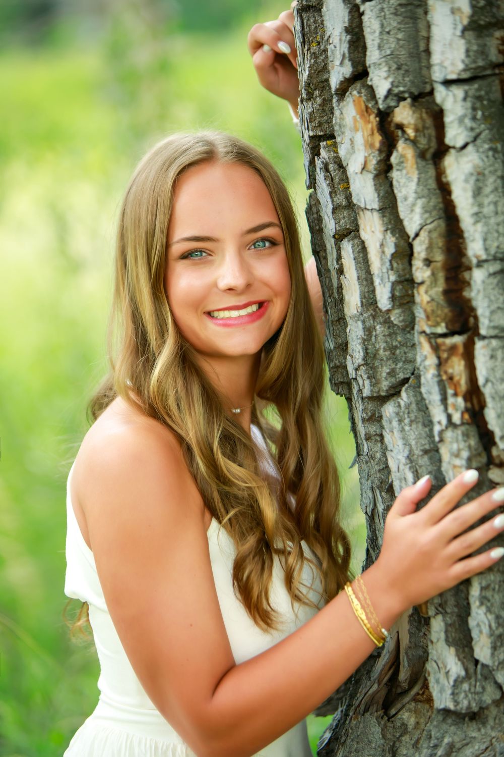 Summer portrait of a person leaning against birch trees in a natural outdoor setting.