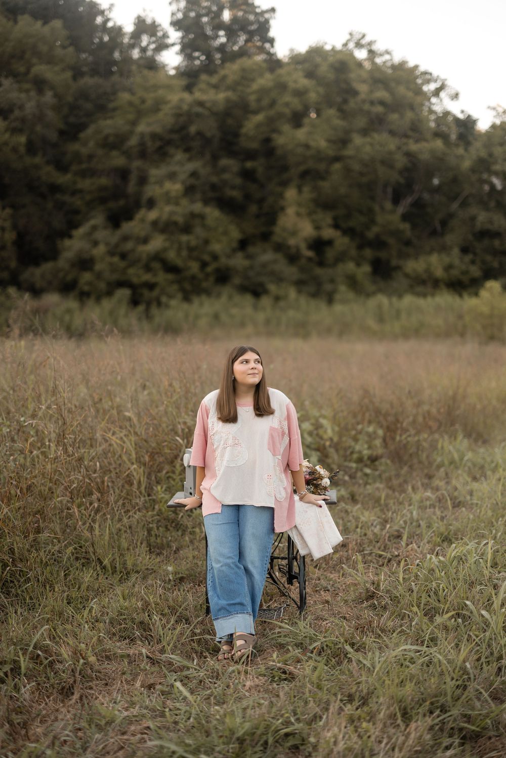Series of photos showing someone walking through a brown autumn field wearing denim and pink on an overcast day.