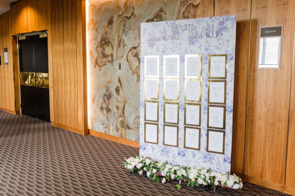 Wood-paneled hallway with floral wallpaper accent and framed documents displayed on the wall in warm lighting.