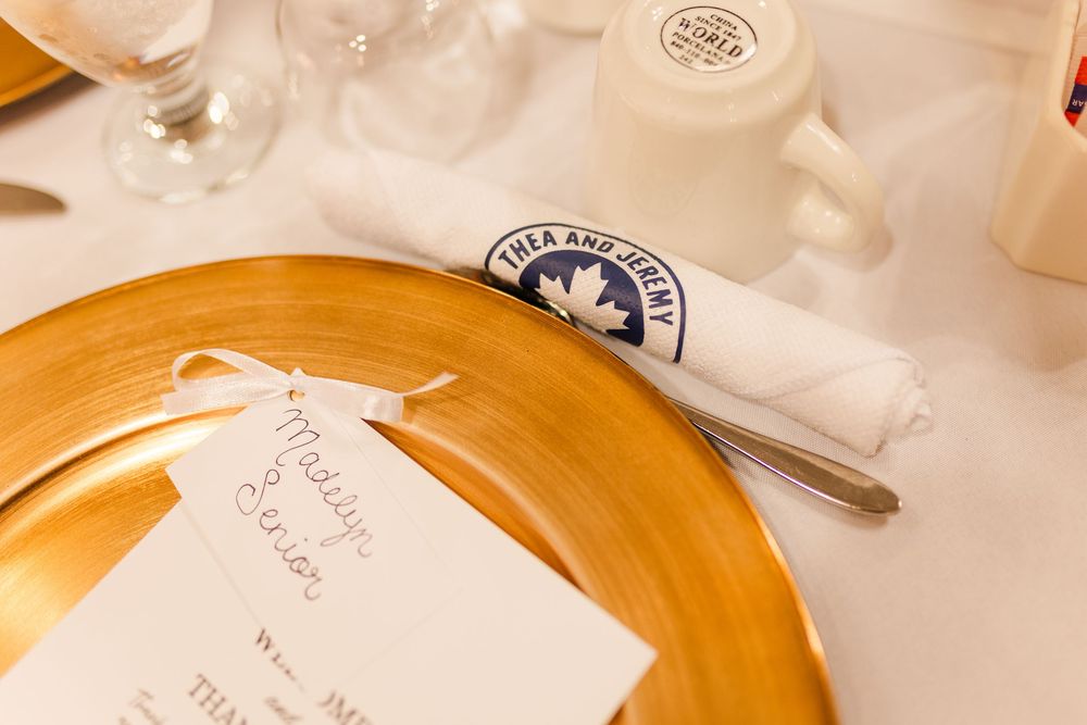 Gold rimmed dinner plates and elegant crystal glassware adorn a formal place setting at an upscale event.