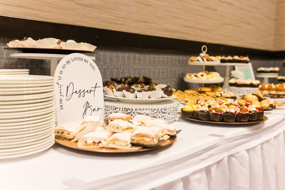 White serving plates and platters arranged on a buffet table with assorted appetizers and desserts.