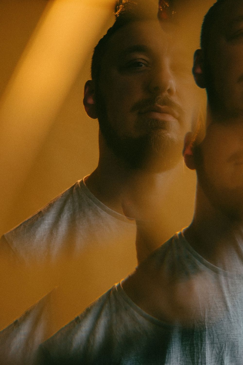 Blurry motion sequence showing a person in dim lighting wearing a white shirt creating an artistic blur effect.