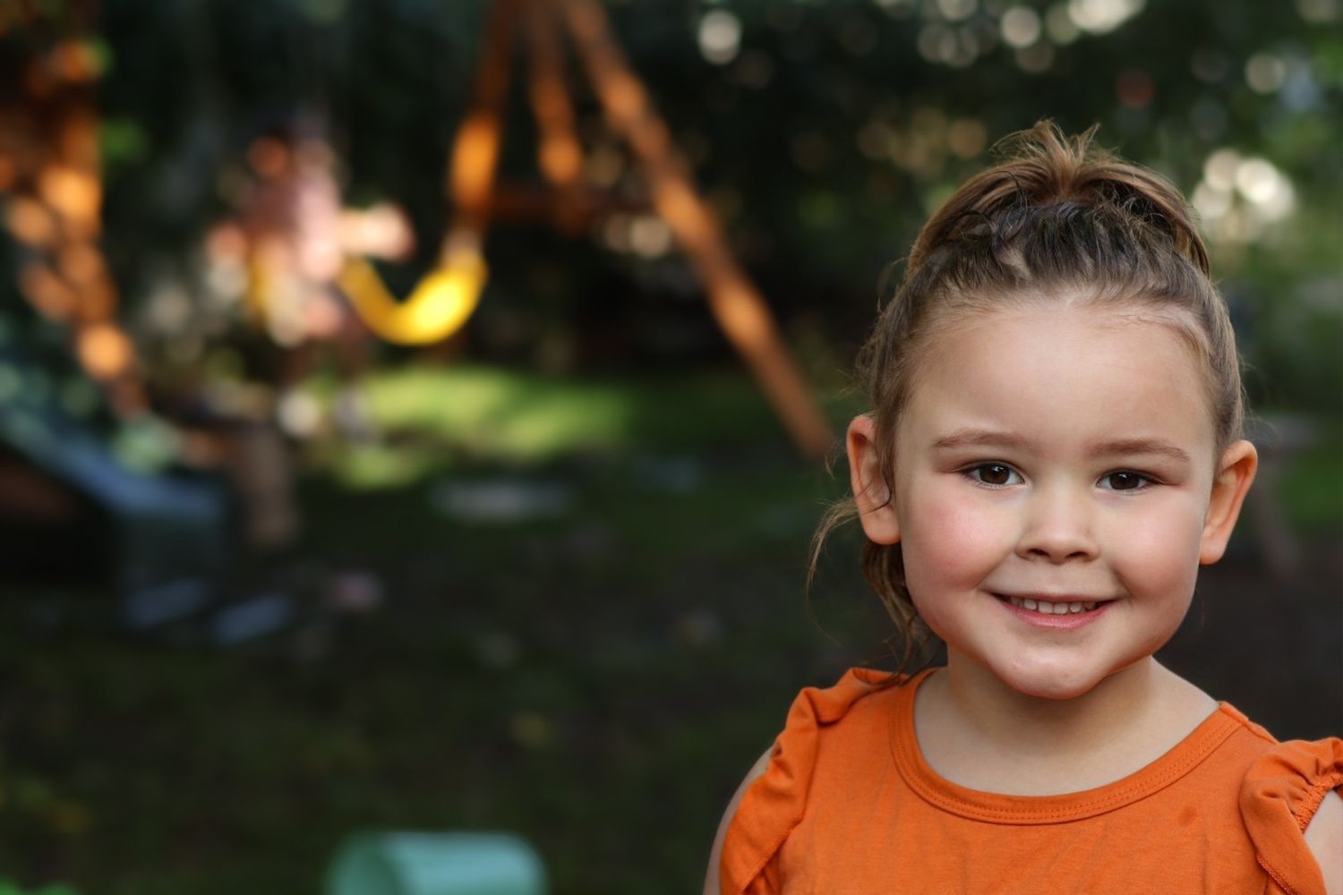 Multiple photos of a child in an orange outfit smiling at the camera outdoors.
