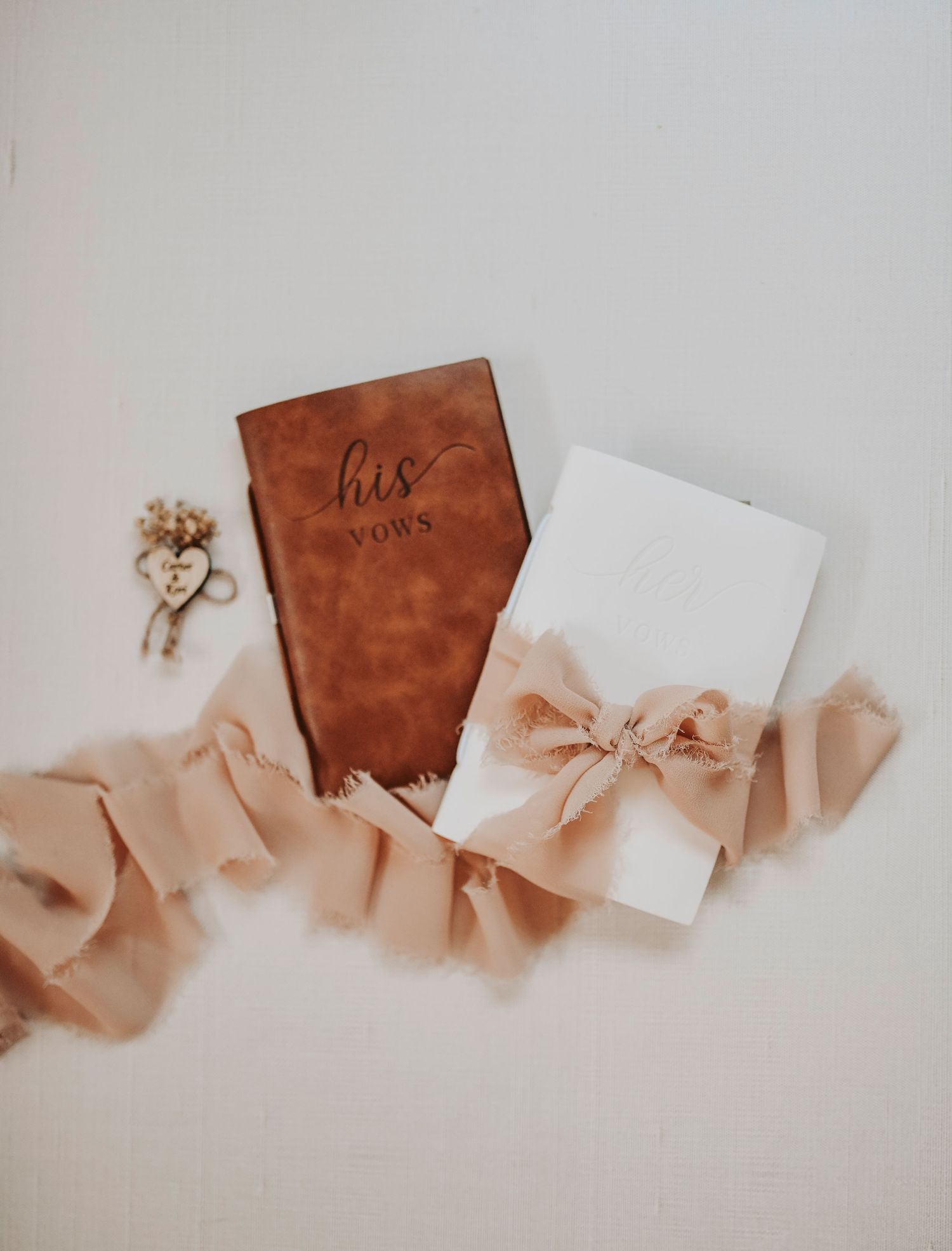 beautiful flat lay of the bride and groom vow books wrapped in chiffon lace