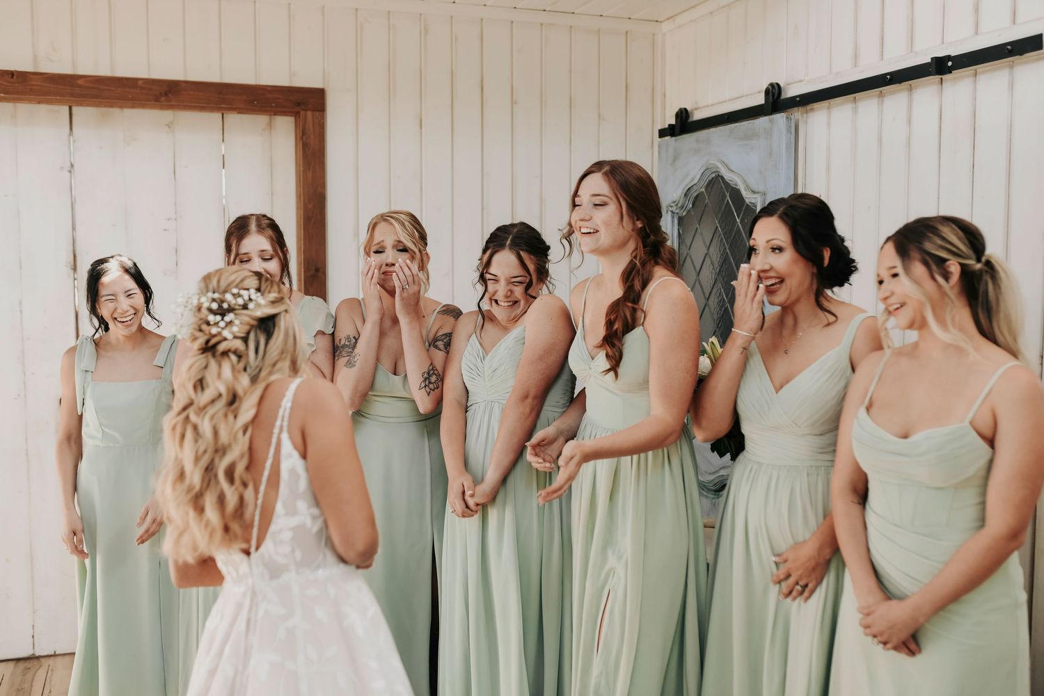 Bridesmaids reacting with joy at bride’s reveal