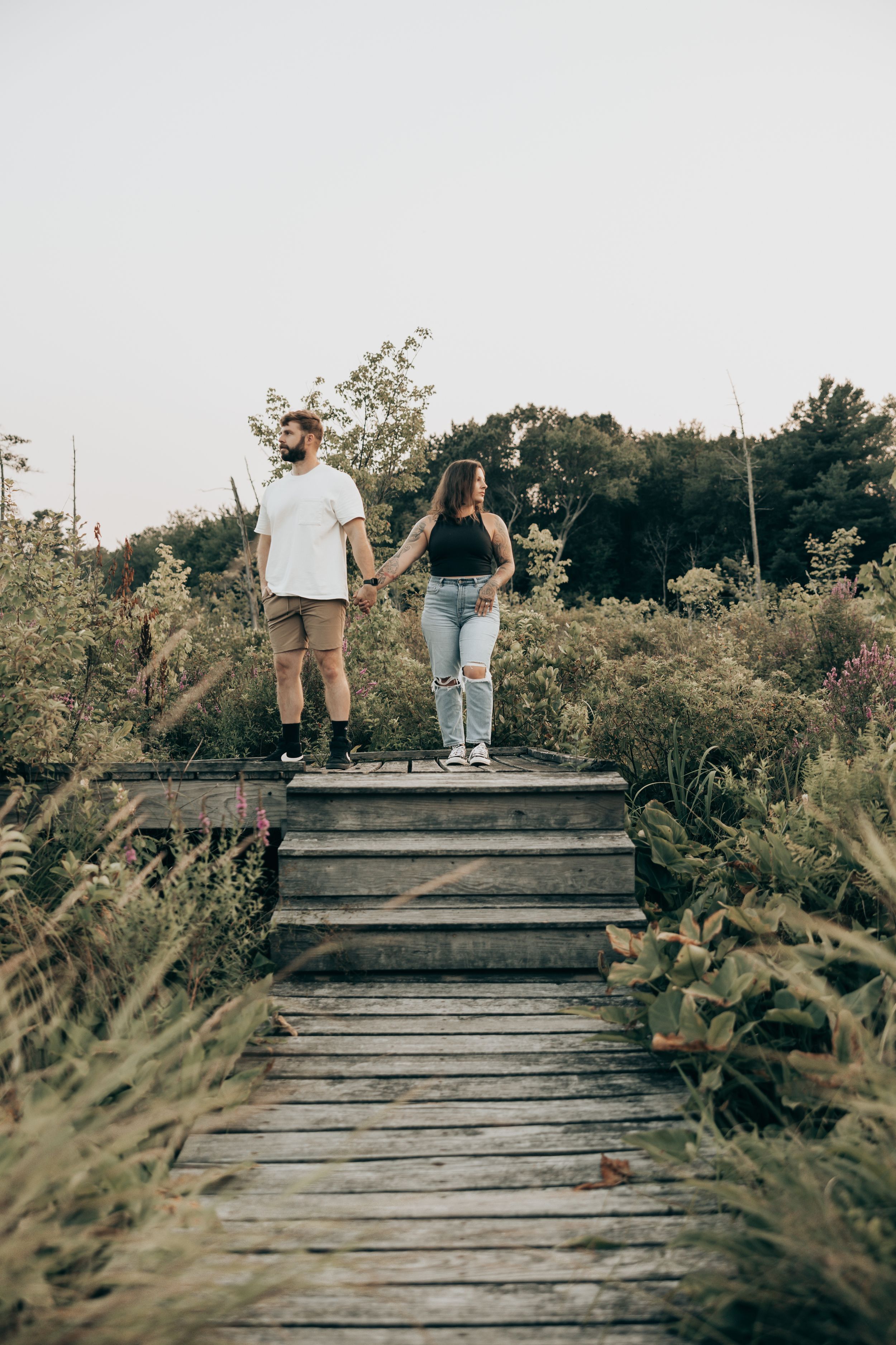A sequence showing a couple's playful movements on a wooden deck surrounded by lush greenery in natural lighting.