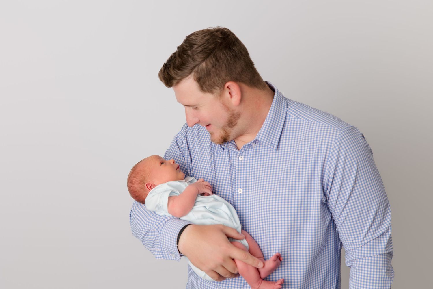 Family posing in a series of minimalist studio shots in matching blue and gray attire.
