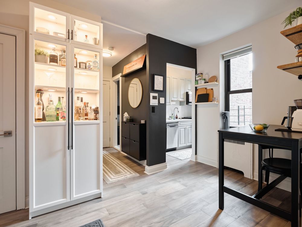 Modern white and black kitchen design with sleek appliances and minimalist cabinets in an open-concept layout.