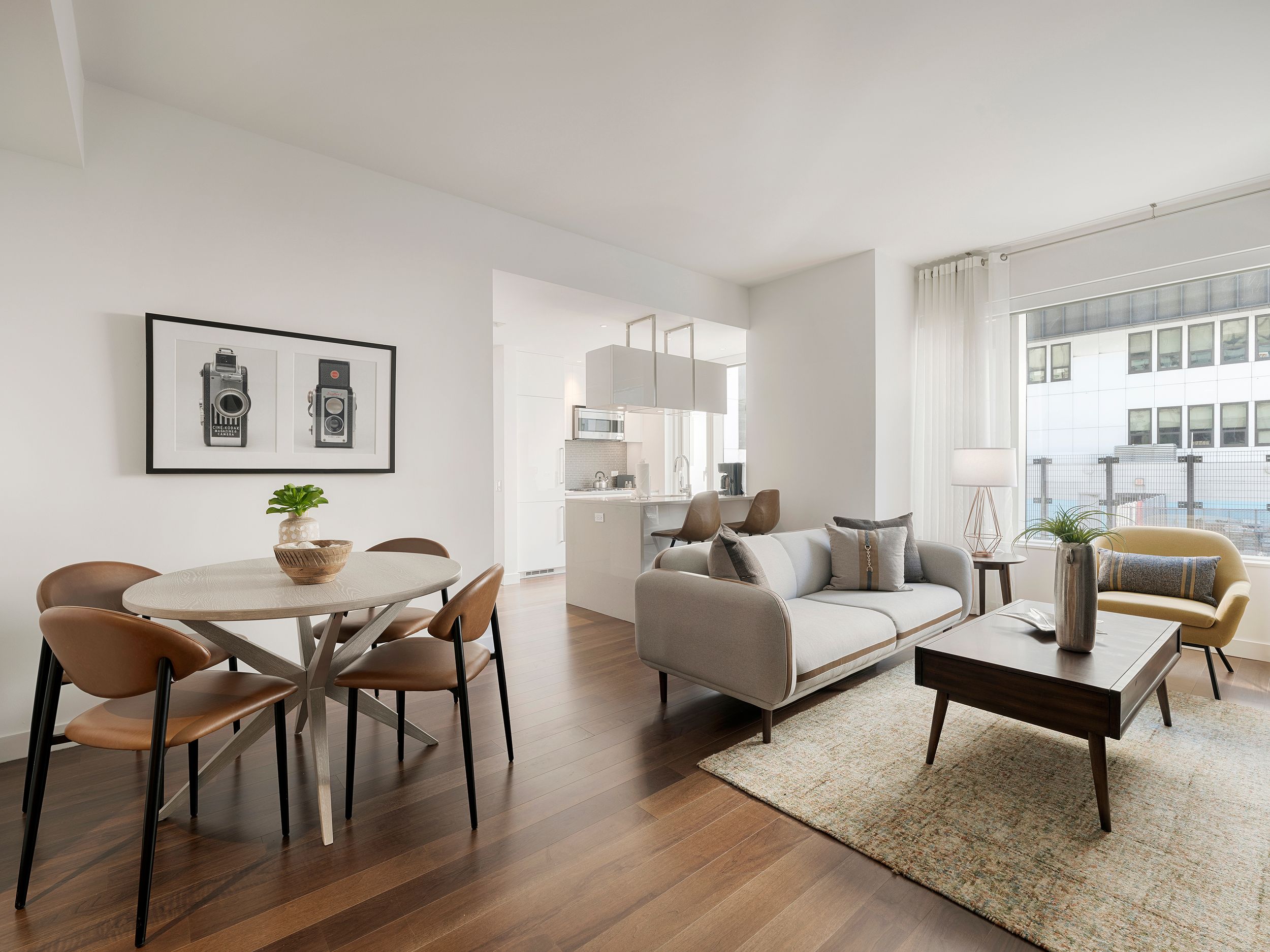 Modern minimalist rental apartment interior featuring white and wood finishes with open concept living and dining areas.