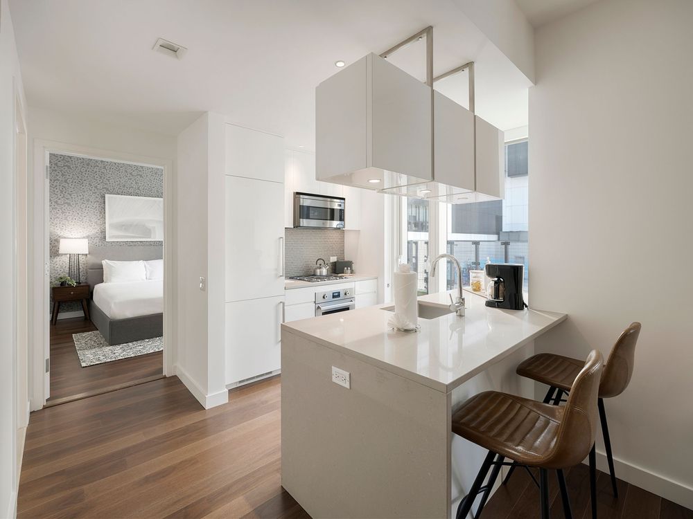 Modern minimalist white apartment interior with clean lines, hardwood floors, and bright natural lighting throughout.