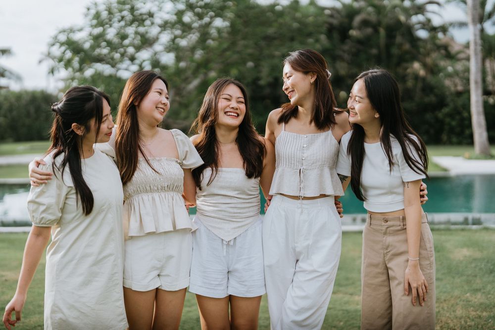 Group wearing coordinated white outfits posing together outdoors.