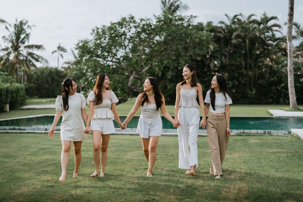 Group walking together on manicured lawn with palm trees in background.