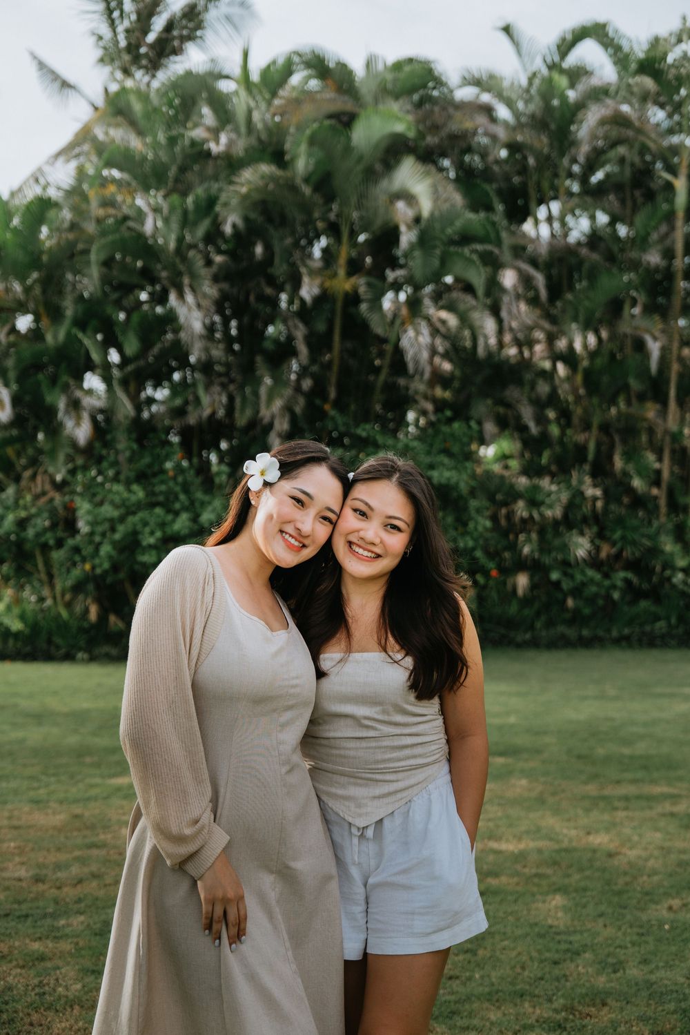 Friends in casual outfits sharing a joyful moment in a tropical garden setting.
