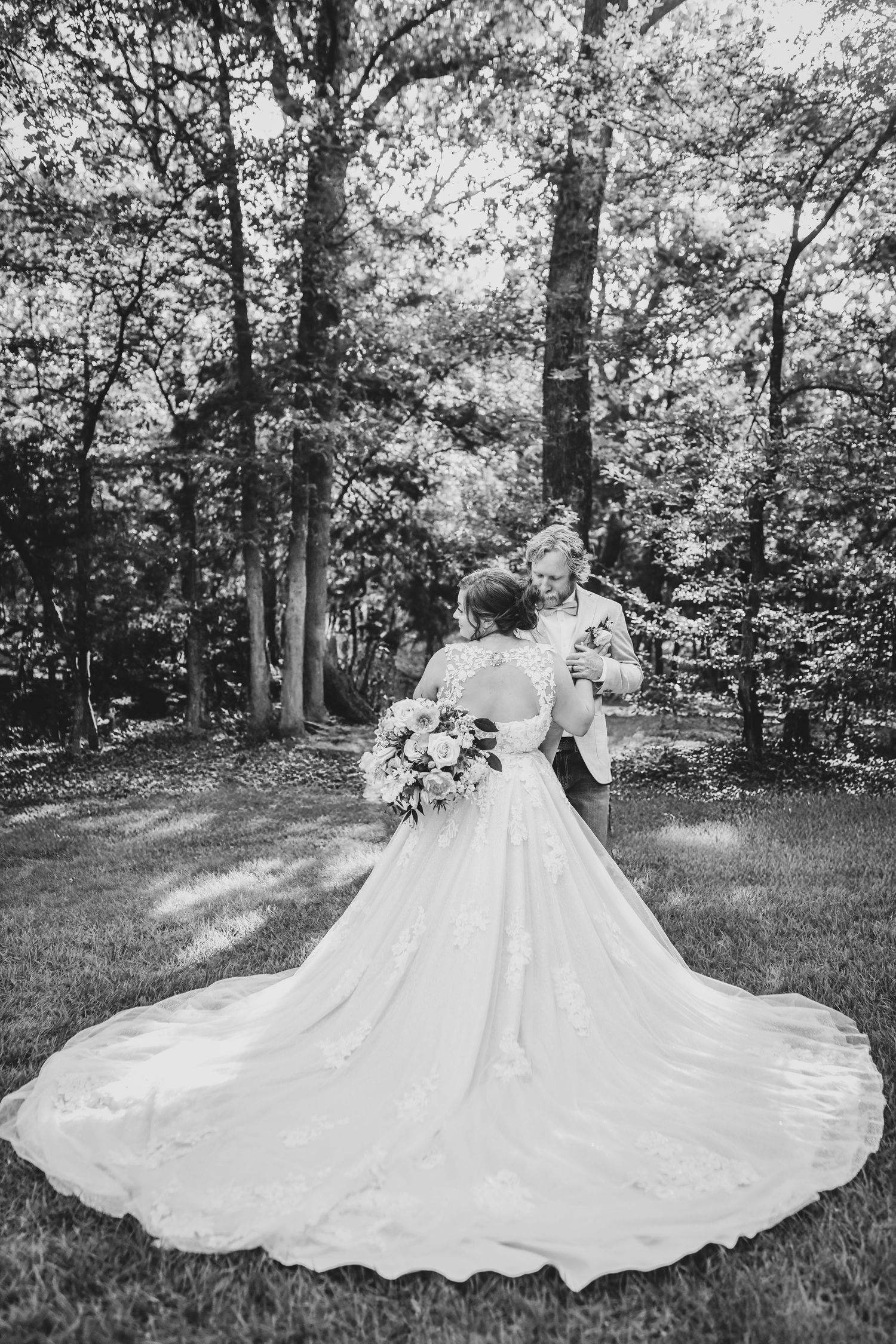 a romantic embrace between a groom and his bride as they enjoy their post ceremony wedding photos at whispering oaks