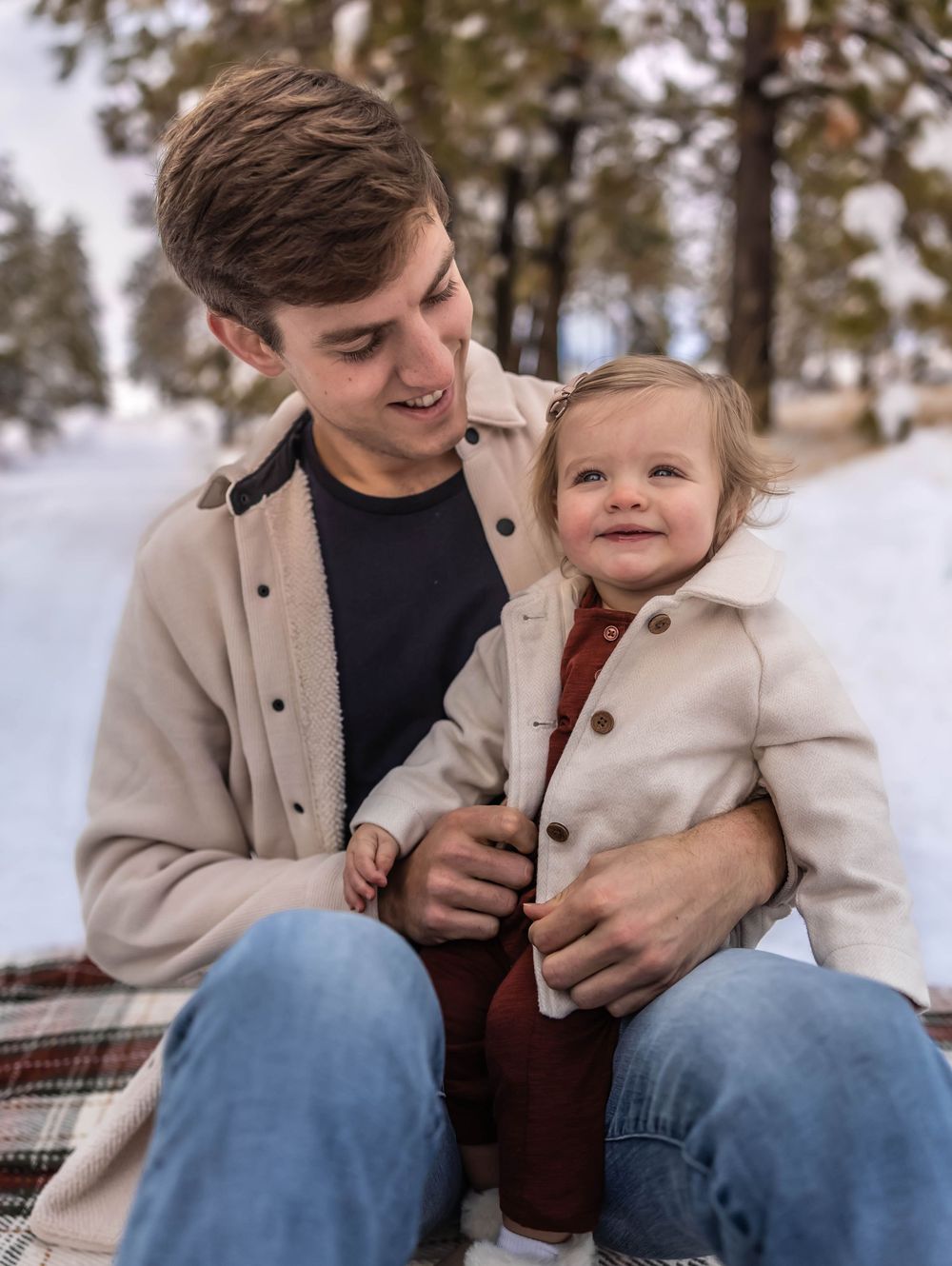 A playful moment captured in the snow with winter coats and casual attire.