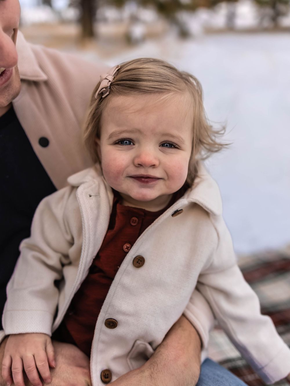 A candid winter scene with cream colored coats against a snowy backdrop.