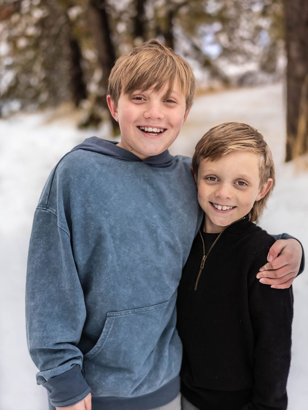 Children in casual winter clothing share joyful moments in snowy outdoor setting.