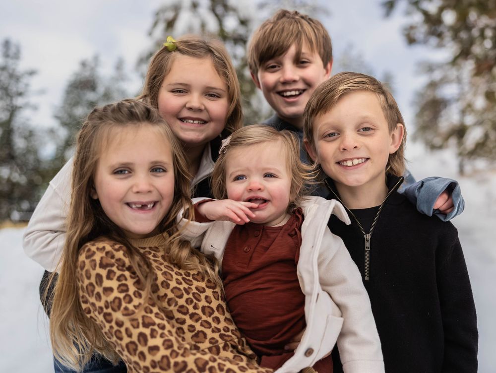 Playful winter family photos with children in coordinated casual outfits.