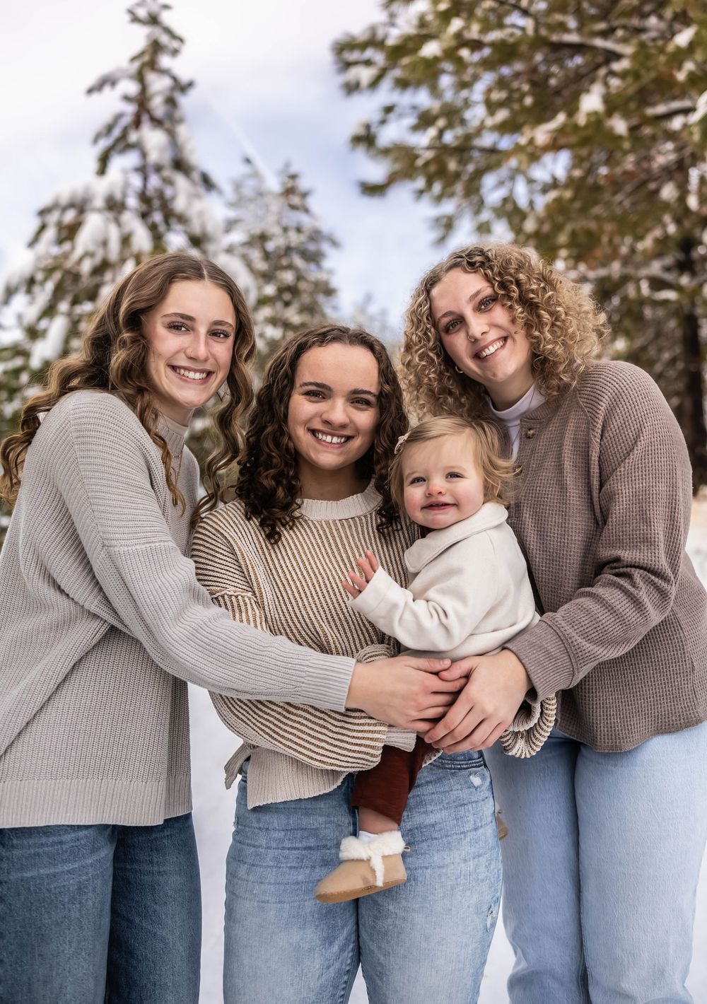 Intimate family moment captured in winter setting with everyone wearing cozy sweaters.