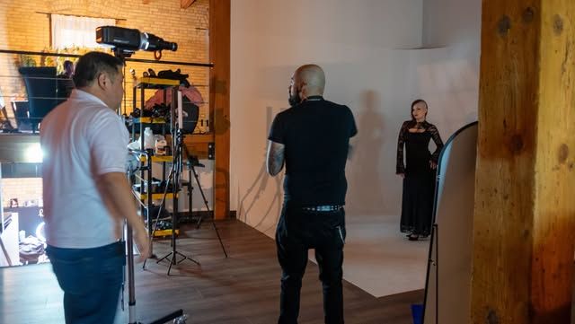 Behind the scenes of photo shoot with camera operators and lighting equipment.