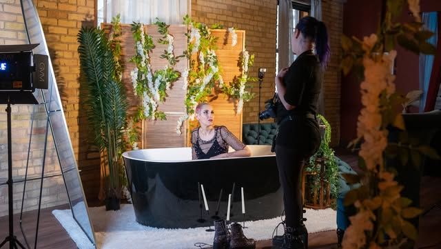 Photography setup in studio with decorative plants and backdrop for creative shoot.