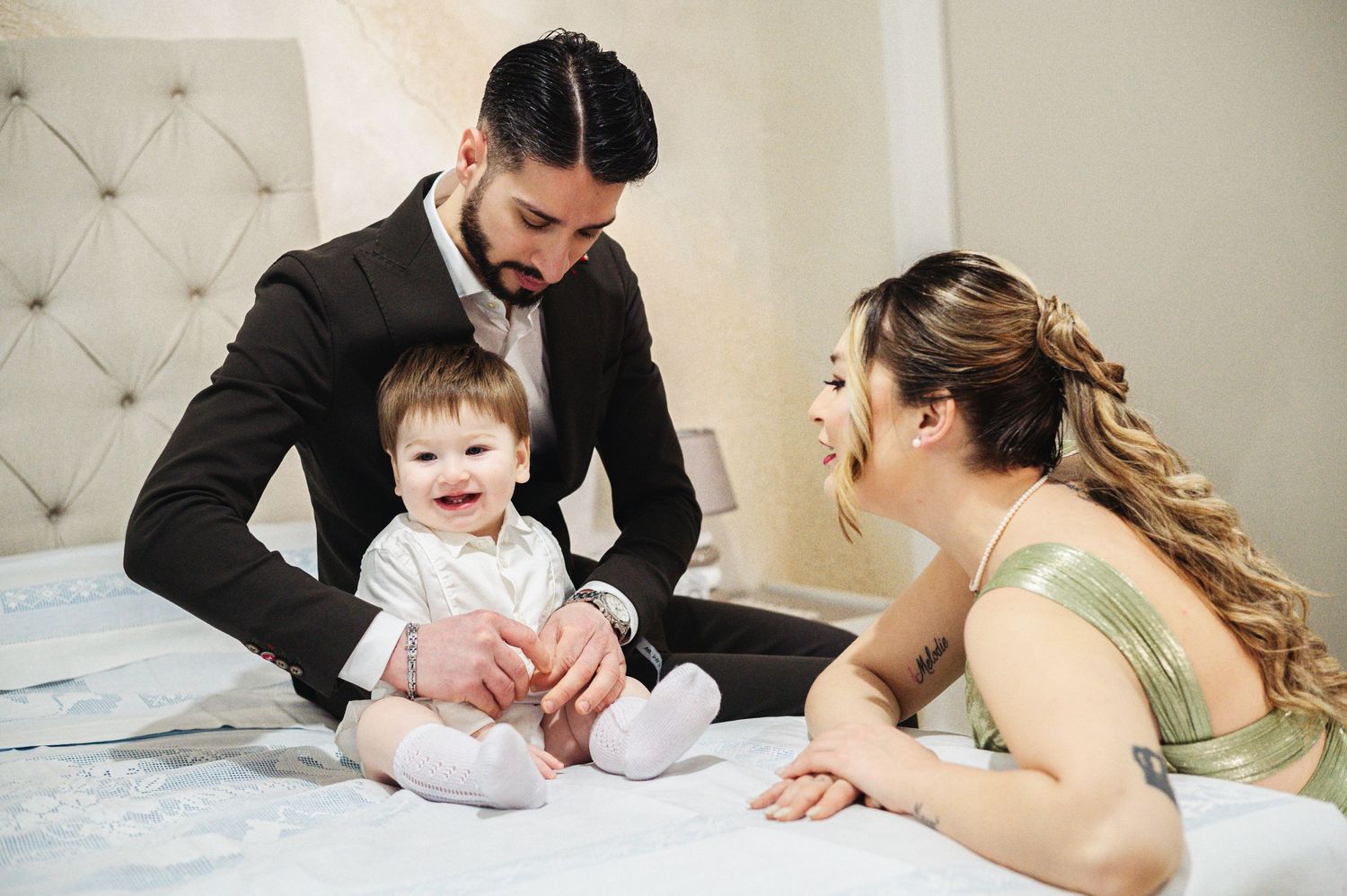 Family gathering on bed sharing intimate moment with baby.