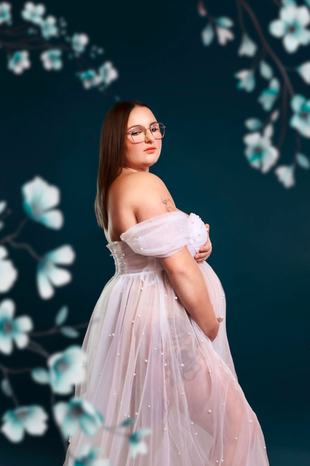 Séance photo artistique en studio d'une femme enceinte, capturée dans un style épuré et élégant, mettant en valeur la beauté de la grossesse