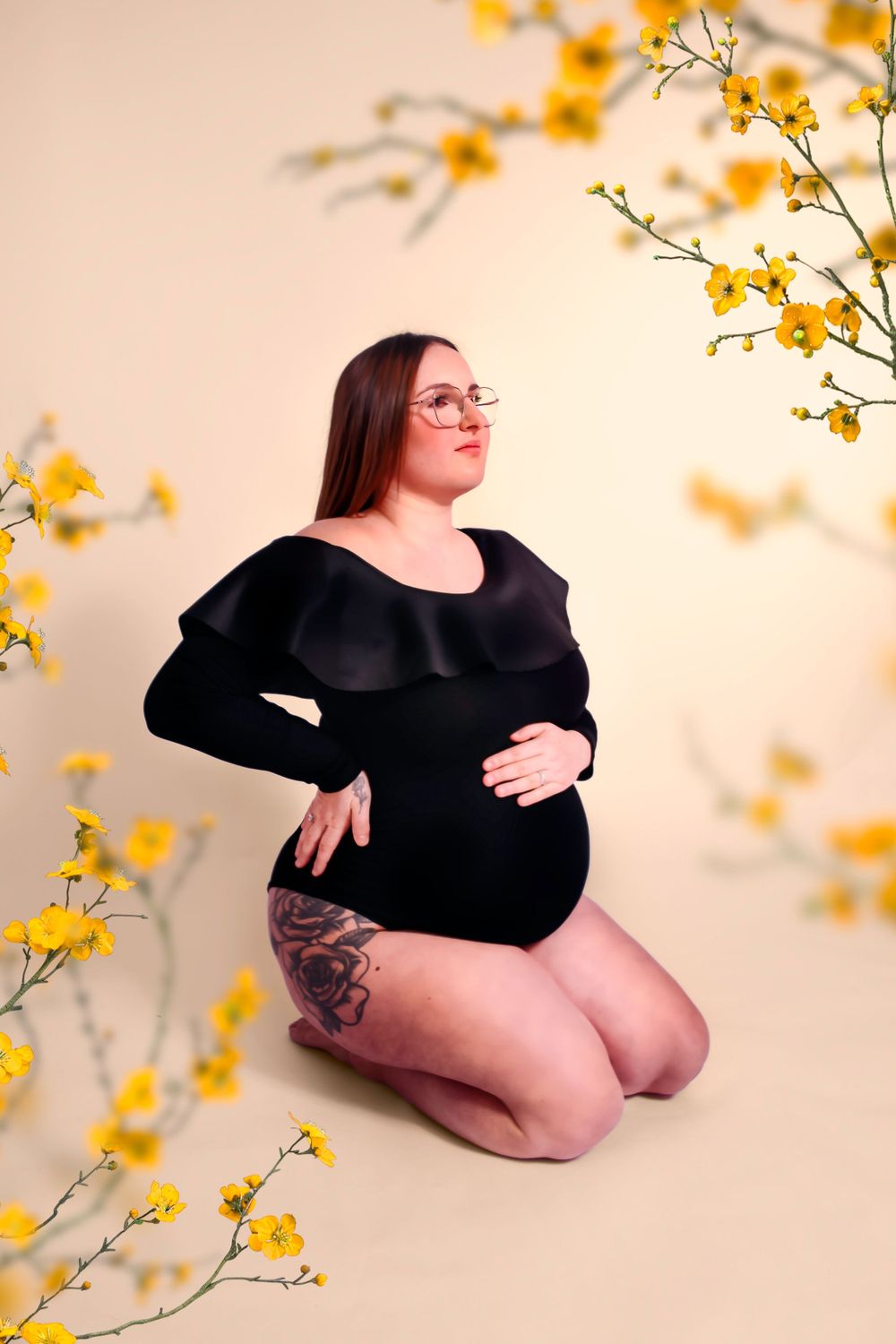 Séance photo artistique en studio d'une femme enceinte, capturée dans un style épuré et élégant, mettant en valeur la beauté de la grossesse