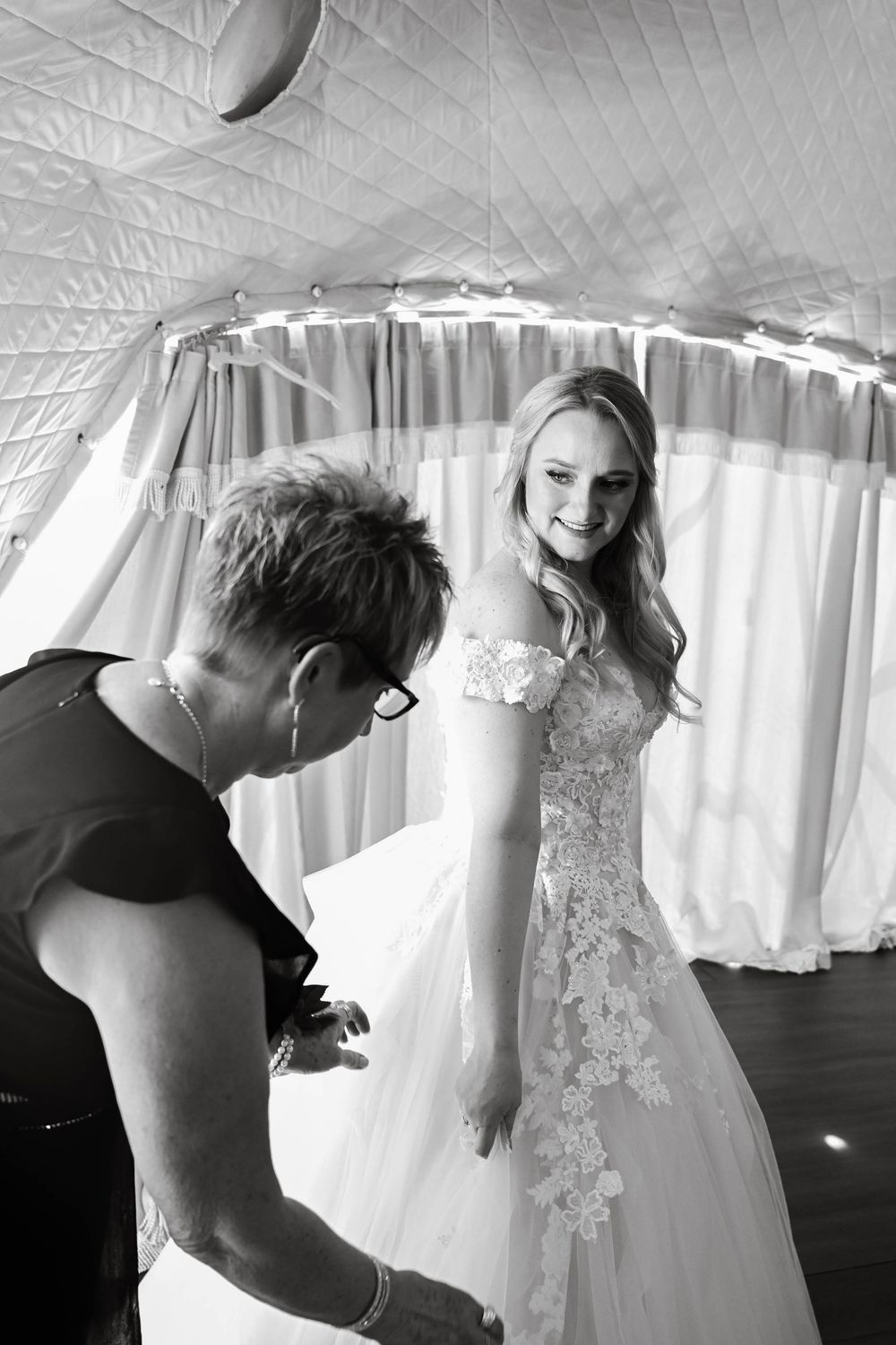 A collection of black and white photos showing the delicate details of wedding dresses on display in a bridal boutique.