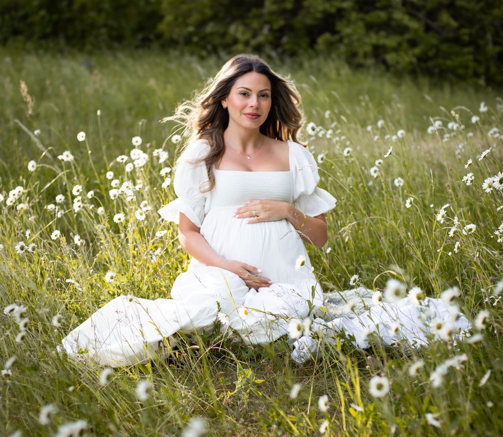 gravidfoto gravidfotografering gravid kvinna klänning blomsteräng motljus