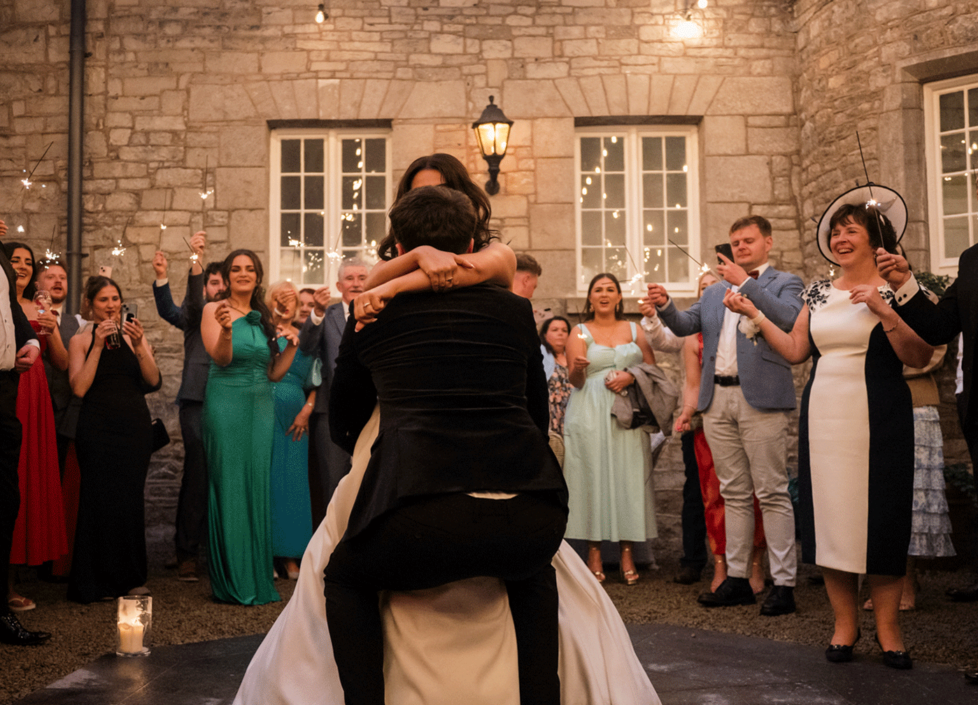 Markree castle, Sligo, Ireland. Luxury Wedding venue. During first dance, groom uplifts bride and spins her. Guests holdings sparklers. gif