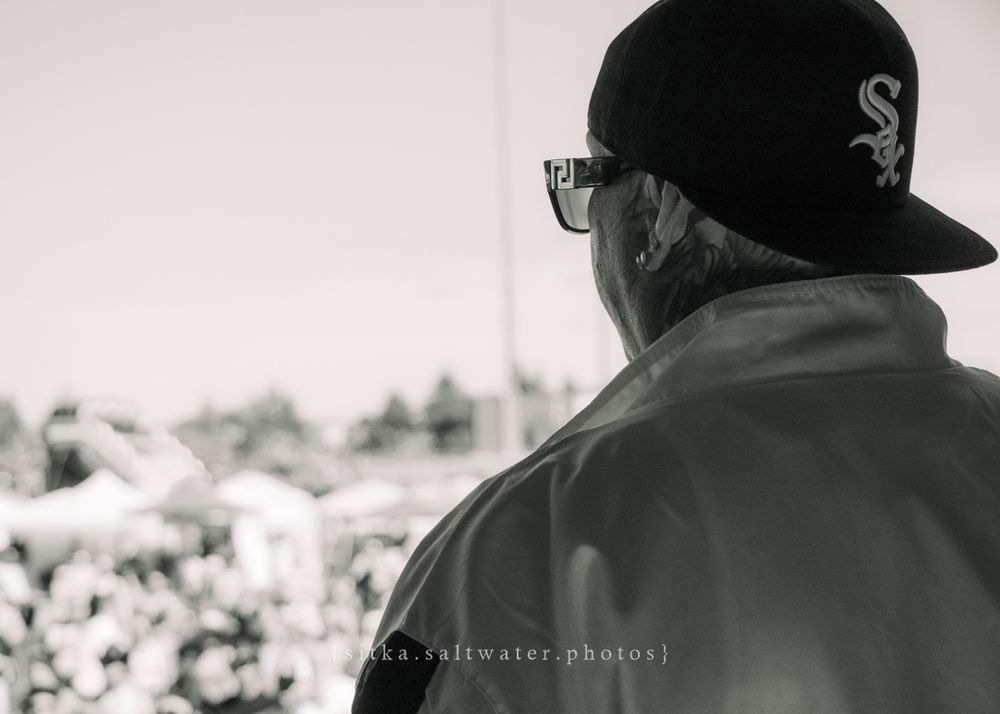 Black and white photo showing someone wearing glasses and a Chicago White Sox baseball cap viewed from behind.