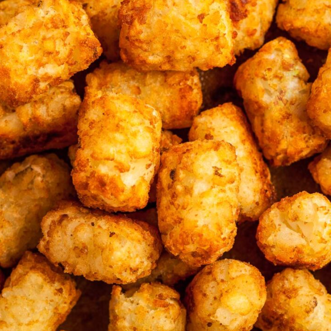 Crispy golden tater tots arranged in a close-up view showing their crunchy exterior texture and warm brown color.