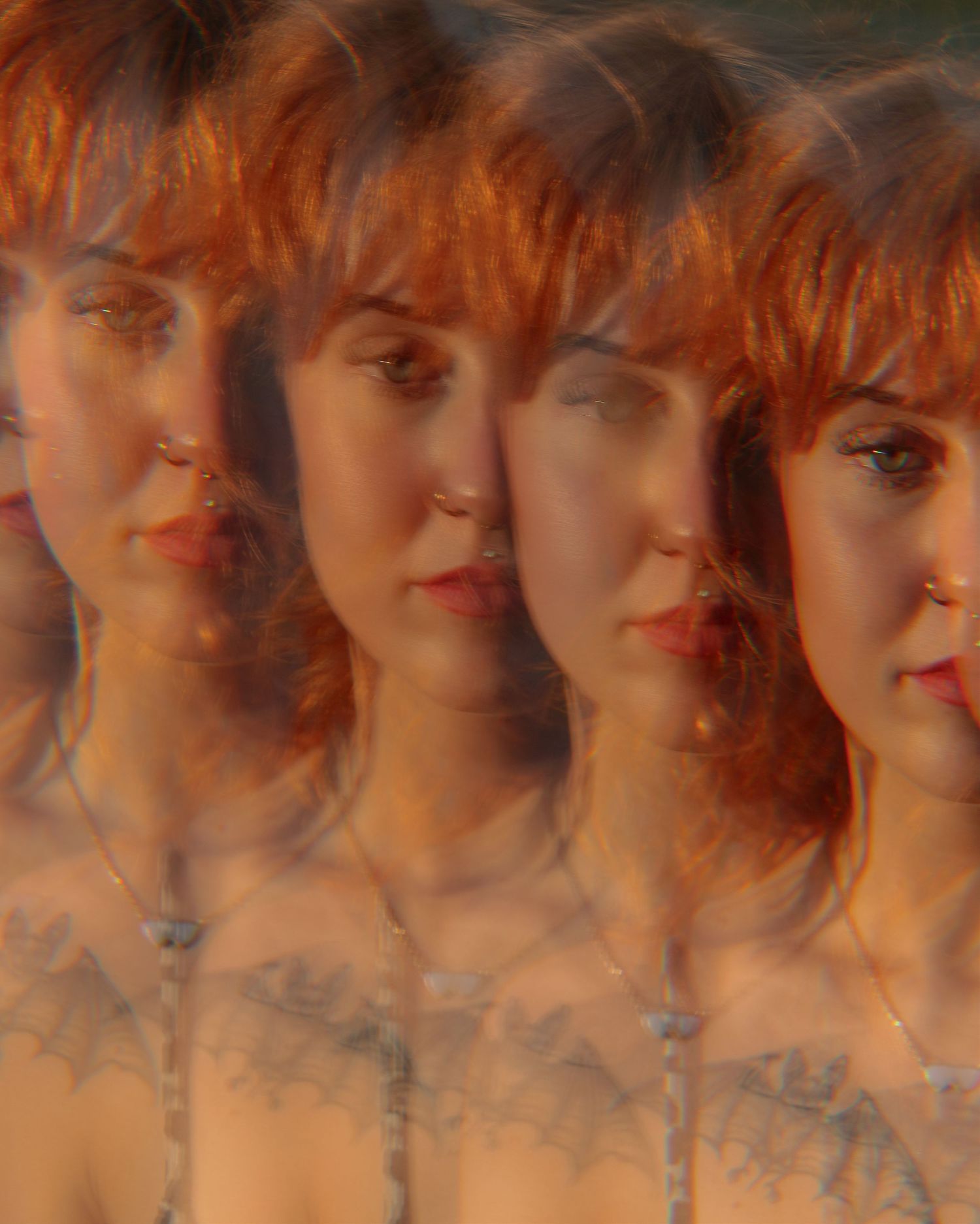 Multiple exposure portrait creating dreamy overlapping effect in warm tones.