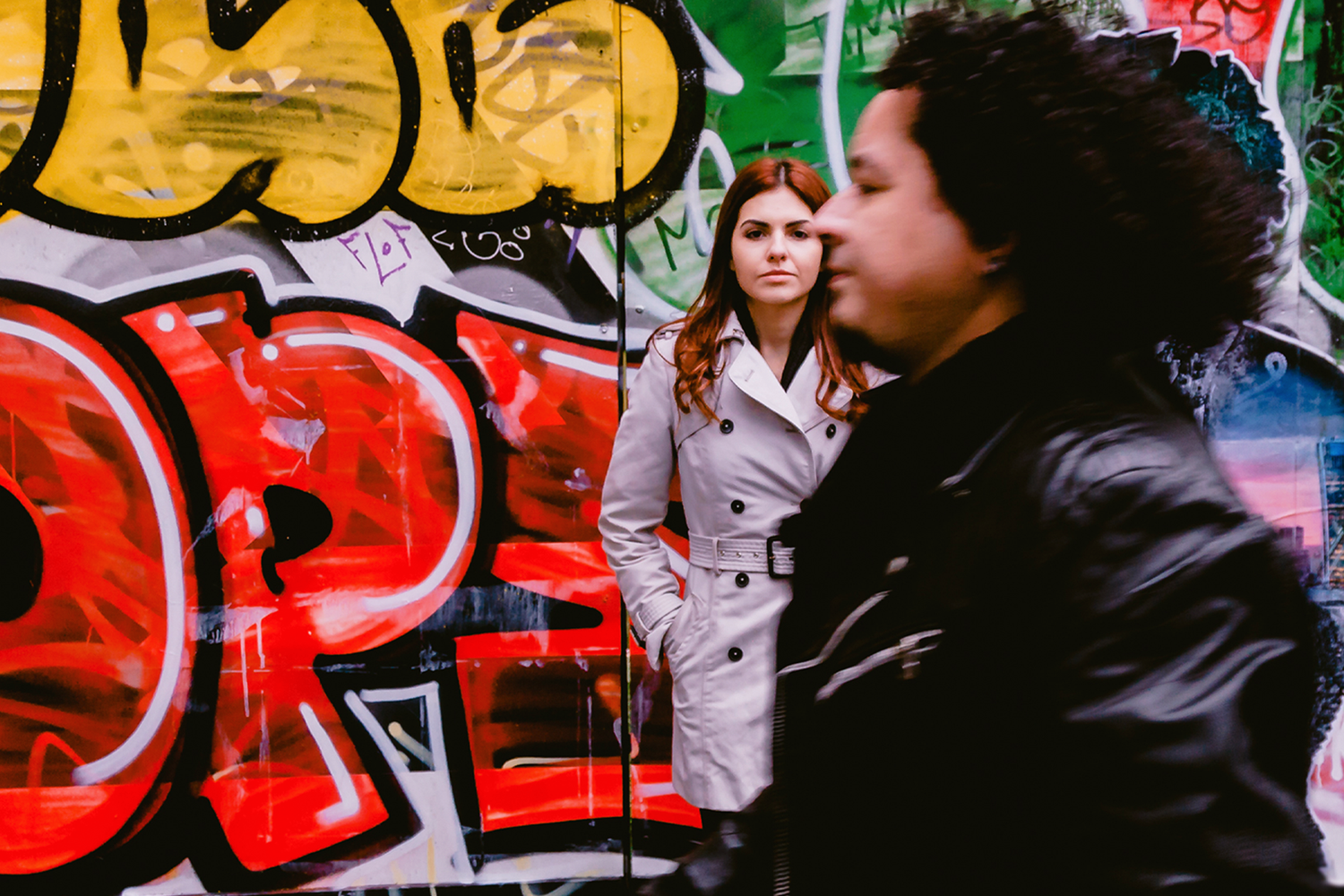 Urban street art scene with red graffiti and brick wall backdrop in city setting.