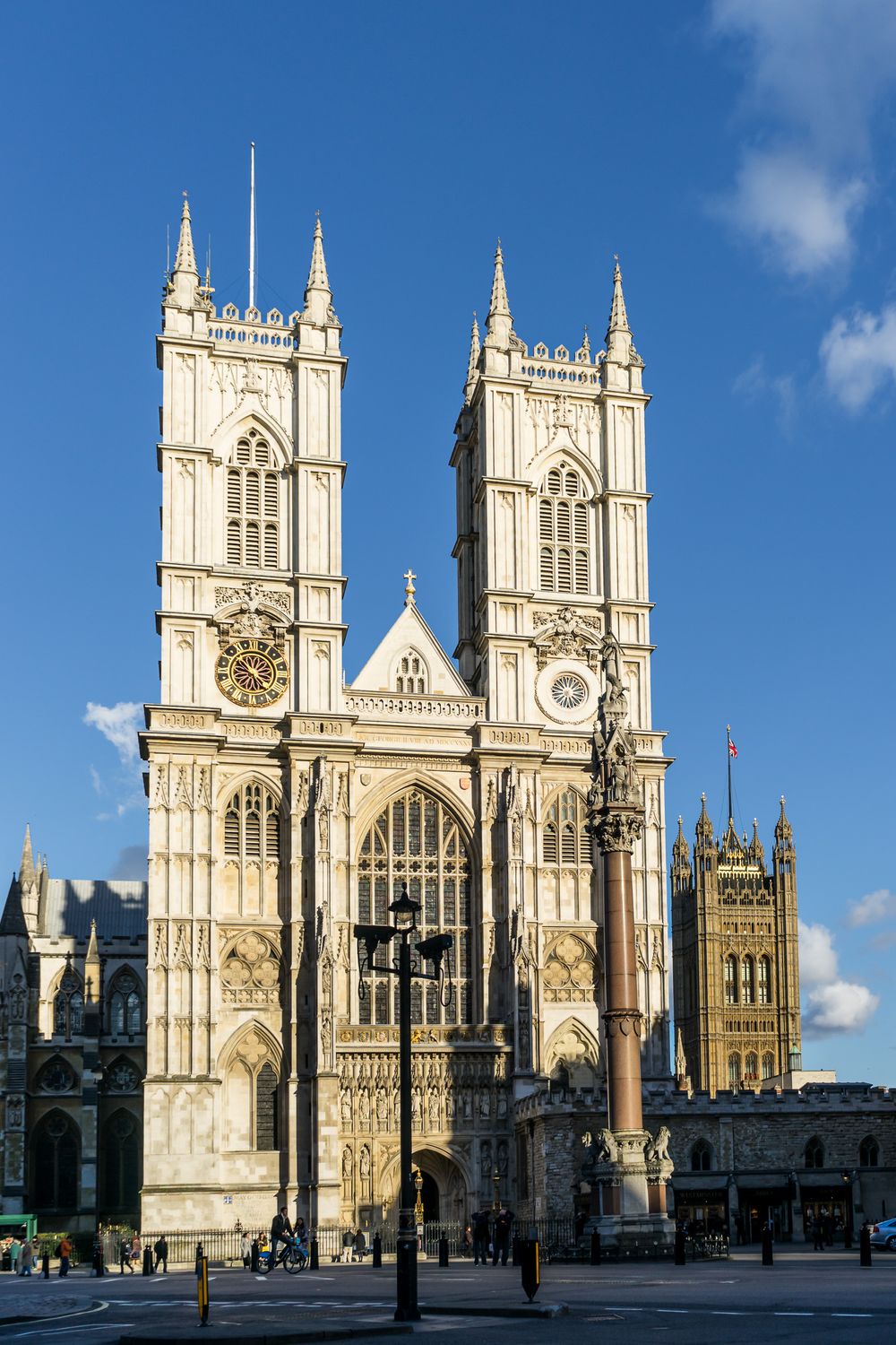 Westminster Abbey's historic Gothic facade stands majestically against a blue sky in London.