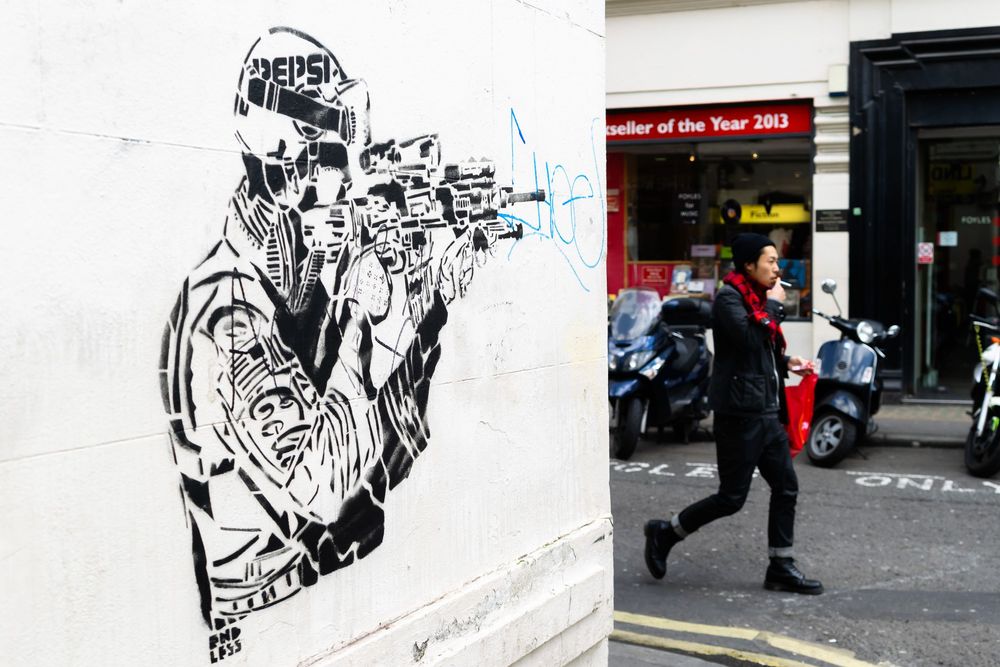 Black and white graffiti art pieces and murals cover urban walls in a photo series showing street scenes and artwork.