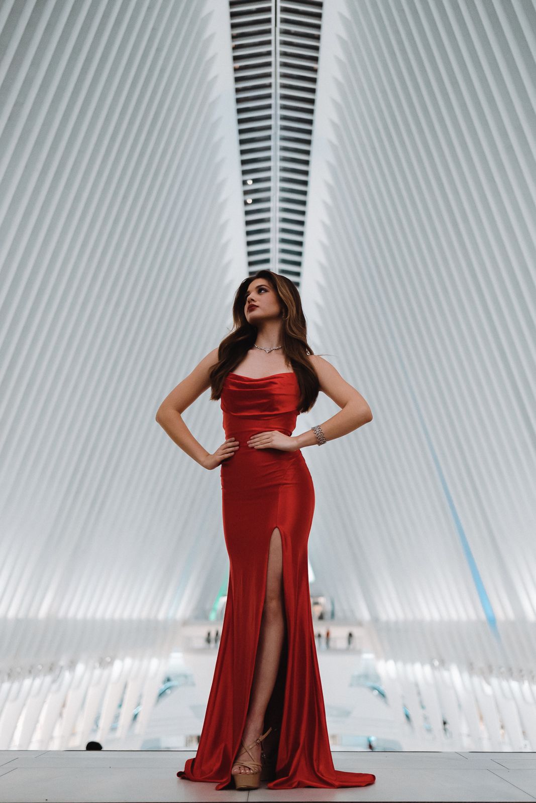 Editorial portrait in Miami of model in elegant red gown framed by modern architecture. Cinematic fashion photography by MannyPortraits.