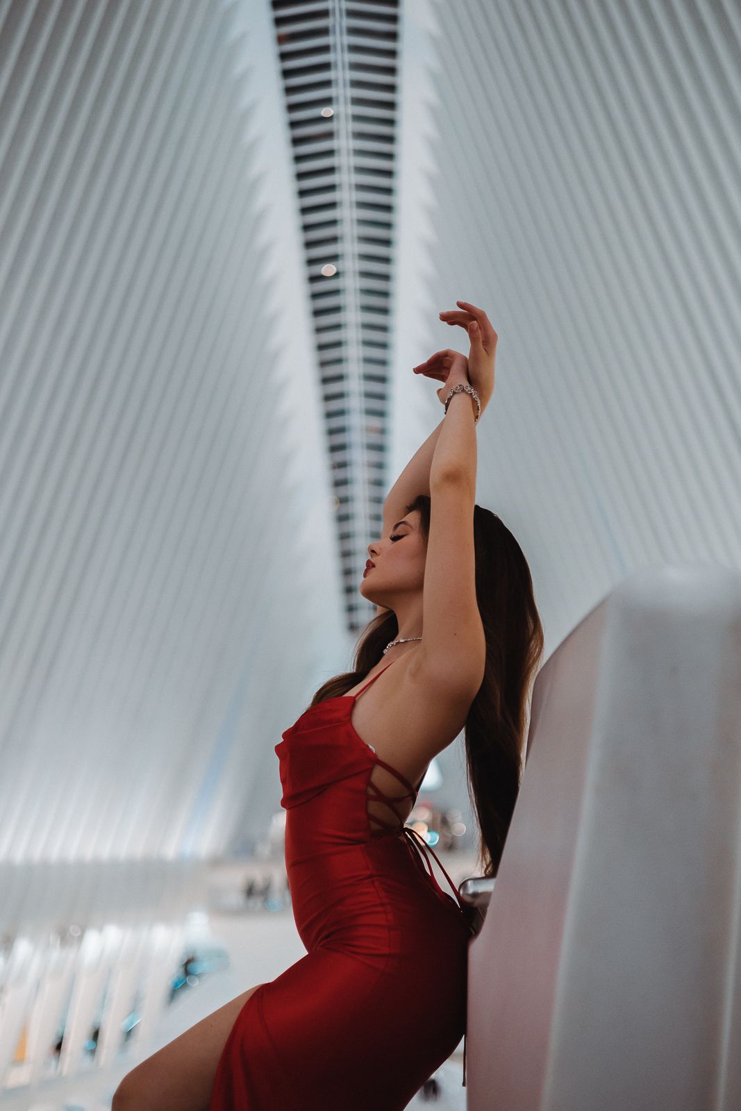 Editorial photo of woman seated in red dress against Miami modern lines. Pinterest-inspired cinematic photography by MannyPortraits