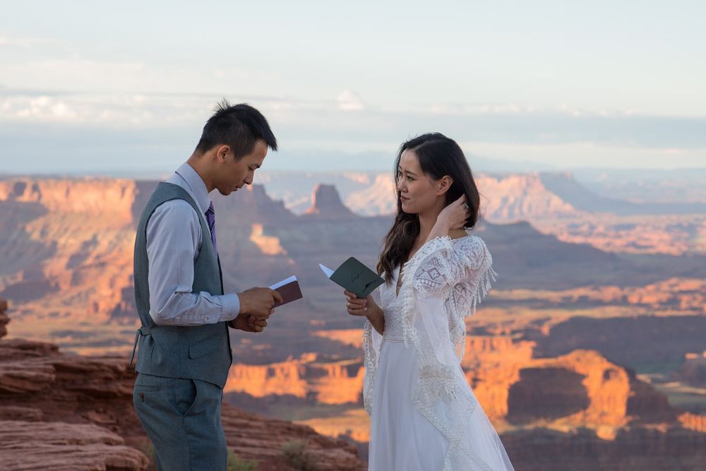 A couple sharing an intimate moment at sunset overlooking the majestic orange cliffs of the Grand Canyon.
