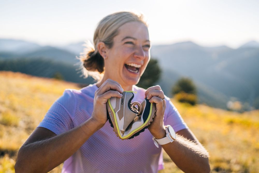Joyful group enjoying scenic vista during golden hour mountain hike together while taking selfie photos.