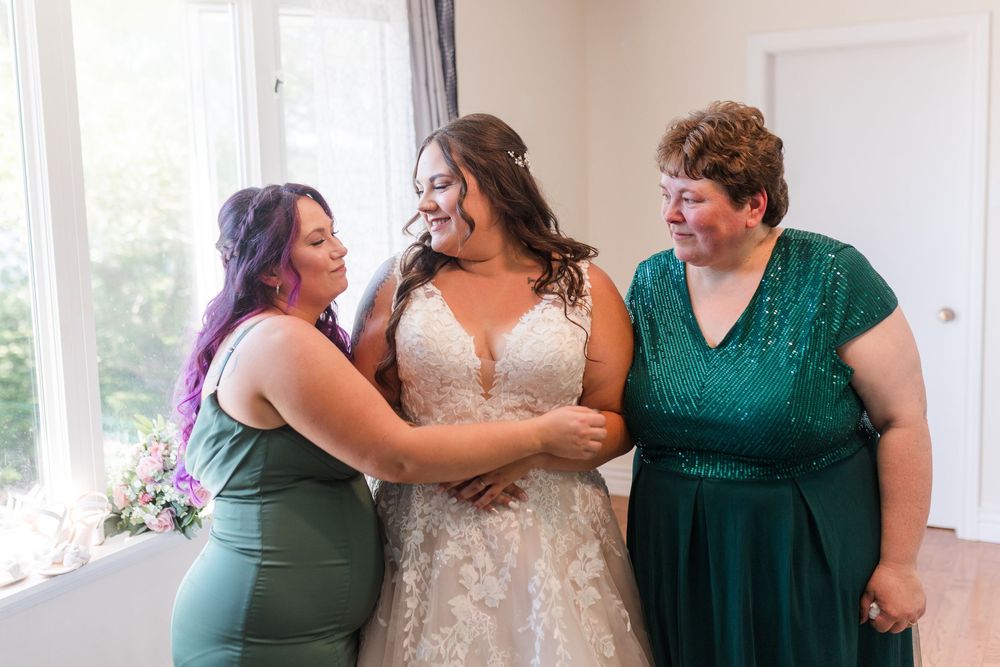 Three happy people share a joyful moment together in matching green and white formal attire.